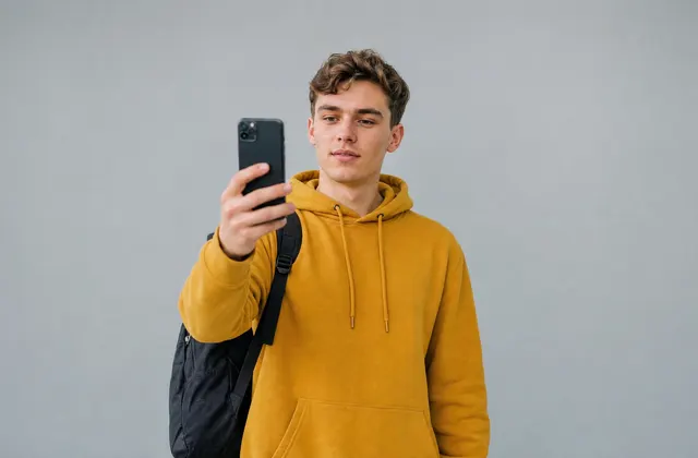 Een student met een rugzak houdt zijn telefoon omhoog om te scannen
